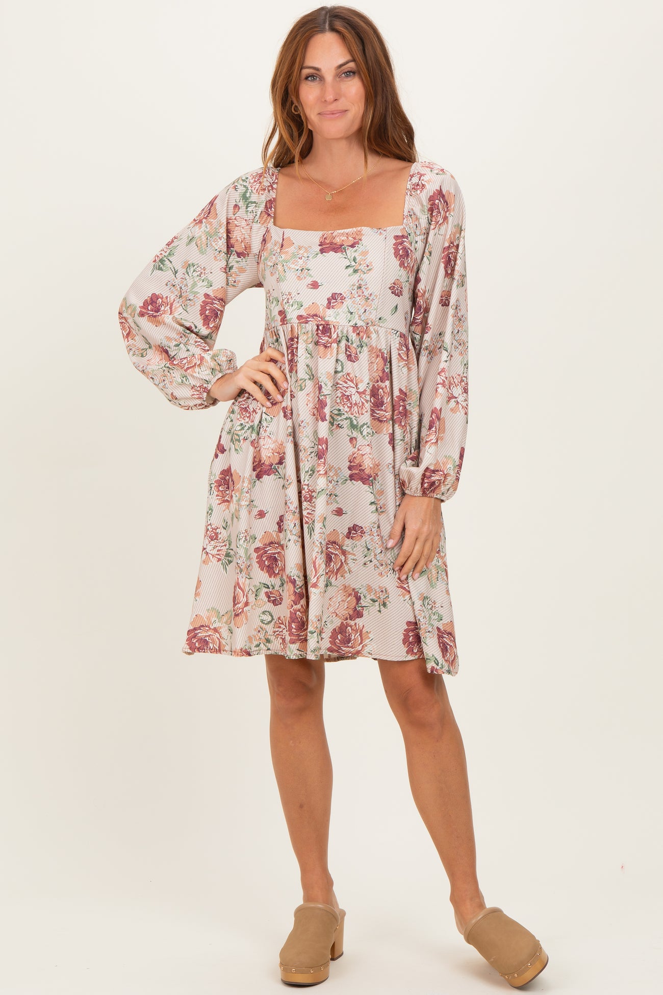 woman wearing a floral print square neck dress with long puff sleeves and a relaxed fit