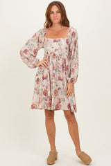woman wearing a floral print square neck dress with long puff sleeves and a relaxed fit