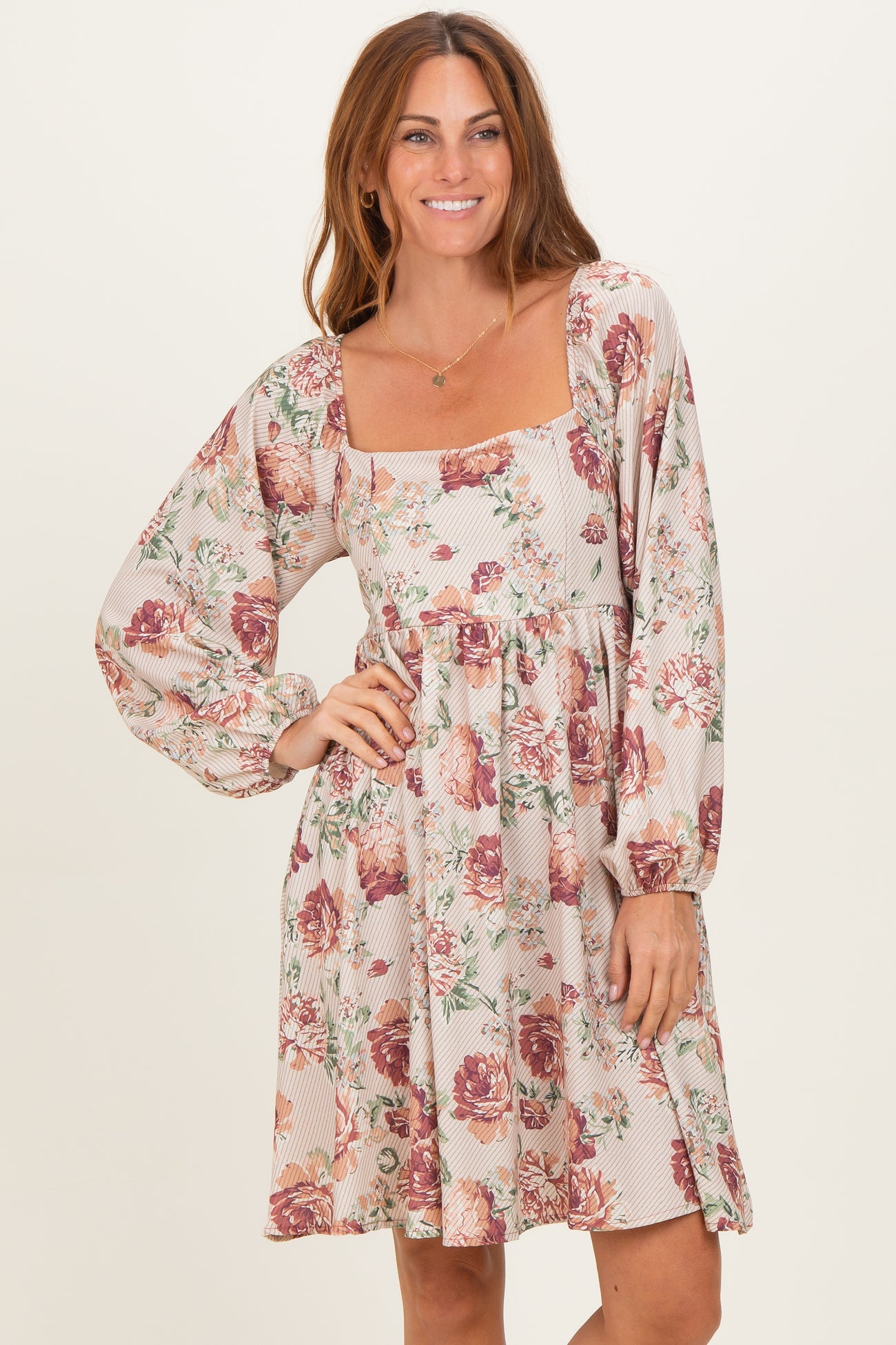 woman wearing a floral print mini dress with puffed sleeves and a square neckline