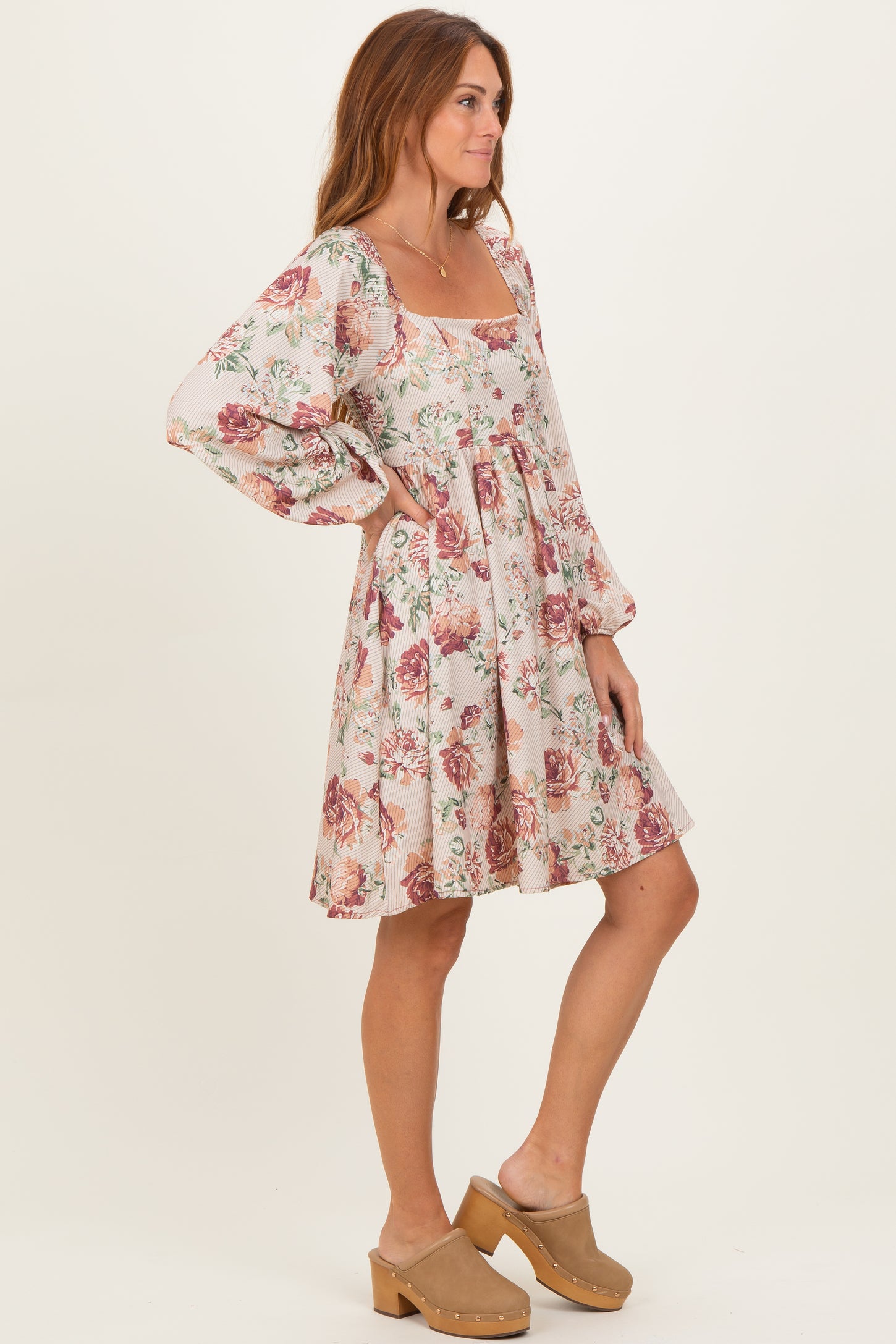 woman wearing a floral printed mini dress with long balloon sleeves and a square neckline