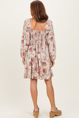 woman wearing a floral print dress with a smocked back and long sleeves, standing with her back to the camera