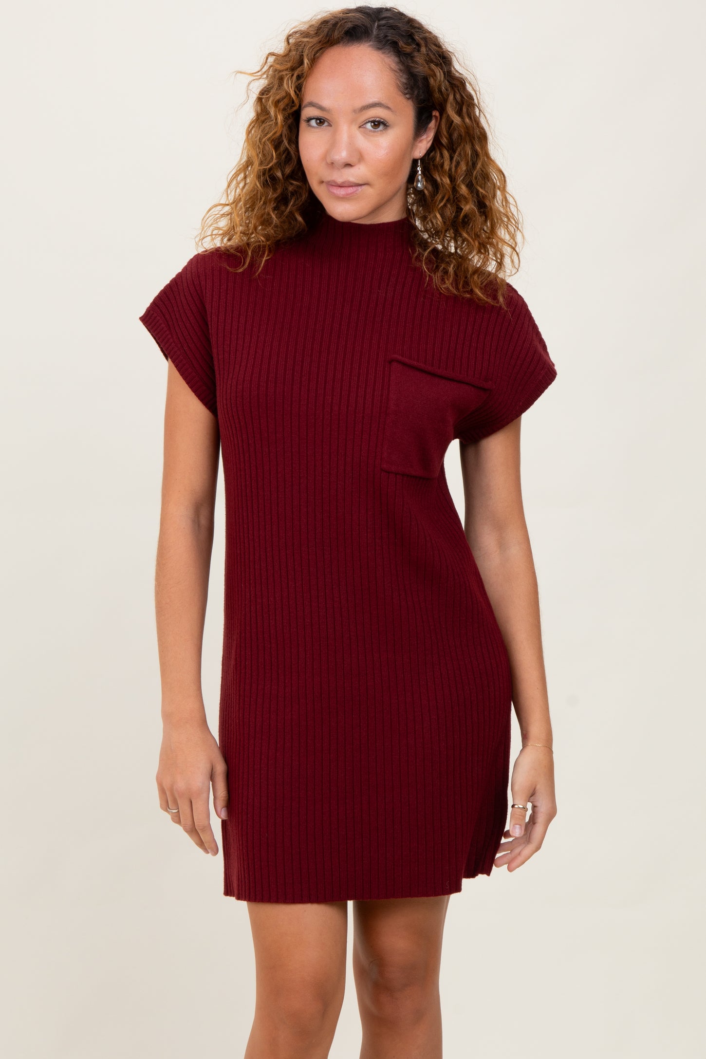 woman wearing a burgundy ribbed knit dress with a short sleeve and a front pocket