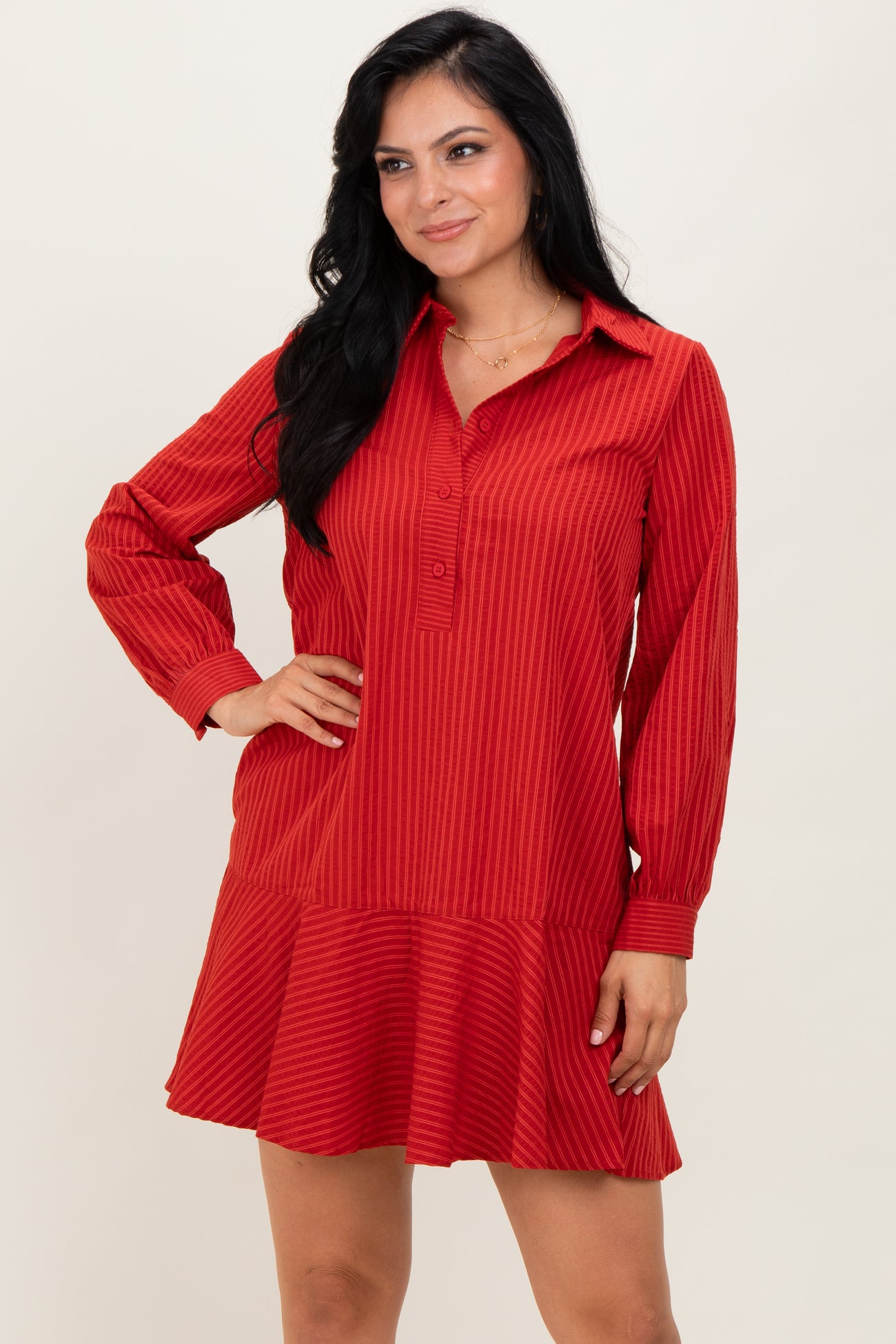 woman wearing a red striped long sleeve dress with a button-up collar and flared hemline