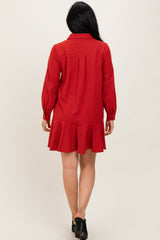 woman wearing a red long-sleeve striped dress with a ruffled hem and a button-up collar, shown from the back