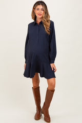 woman wearing a navy striped maternity shirt dress with a flared hem and brown knee-high boots, showing her baby bump