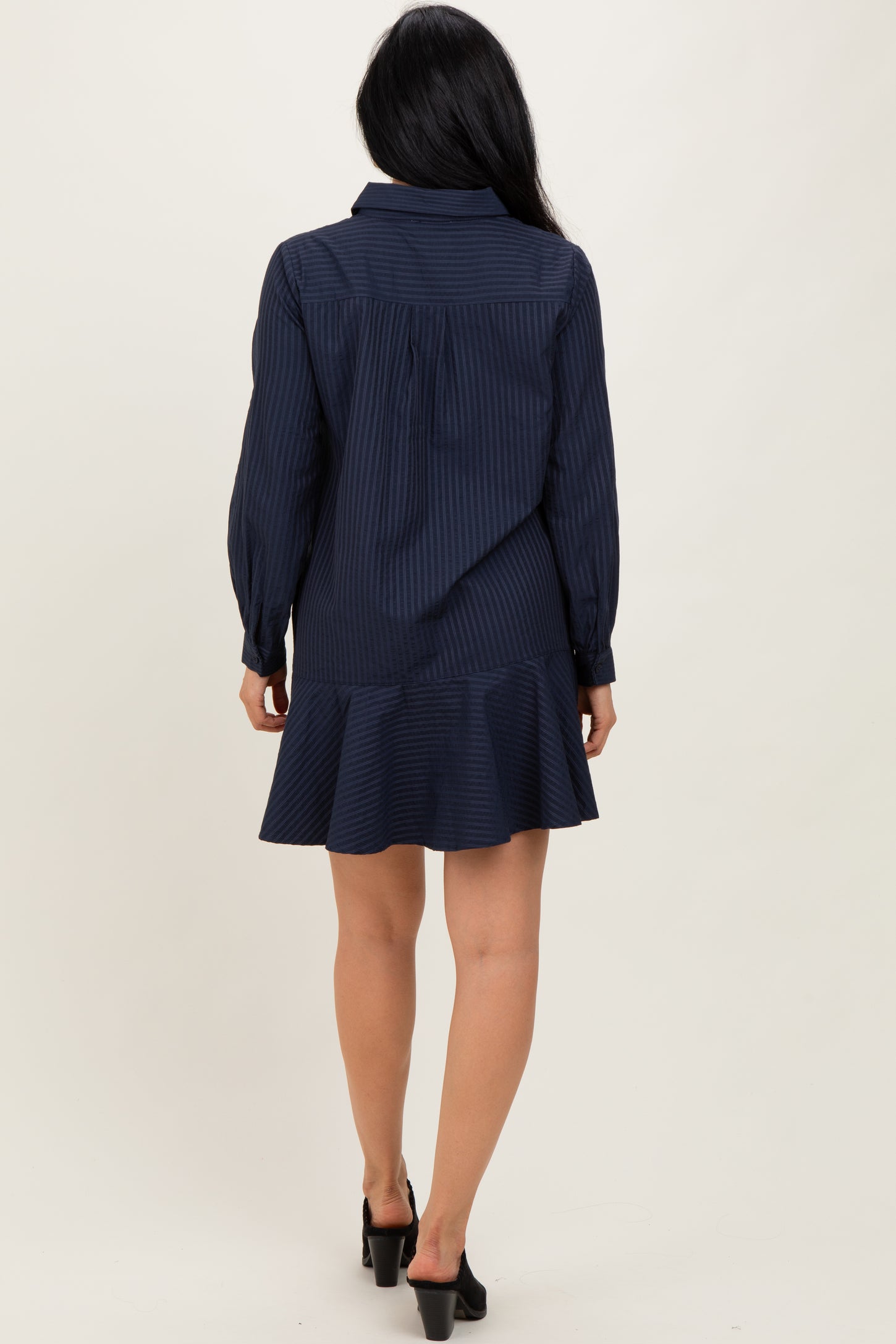 woman wearing a navy blue striped long sleeve shirt dress with a flared hem and back yoke detail