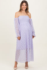woman wearing a lavender off-the-shoulder maternity dress with long sleeves and a flowy skirt, showing her baby bump
