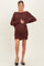 woman wearing a rust cable knit maternity dress and holding her baby bump