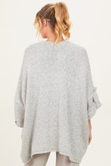 woman wearing a light grey oversized maternity sweater with rolled sleeves, showing the back view