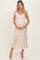 woman wearing a floral print maternity dress with short sleeves and a v-neck, holding her baby bump