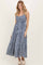 woman wearing a navy and white gingham maxi dress with tiered design and spaghetti straps