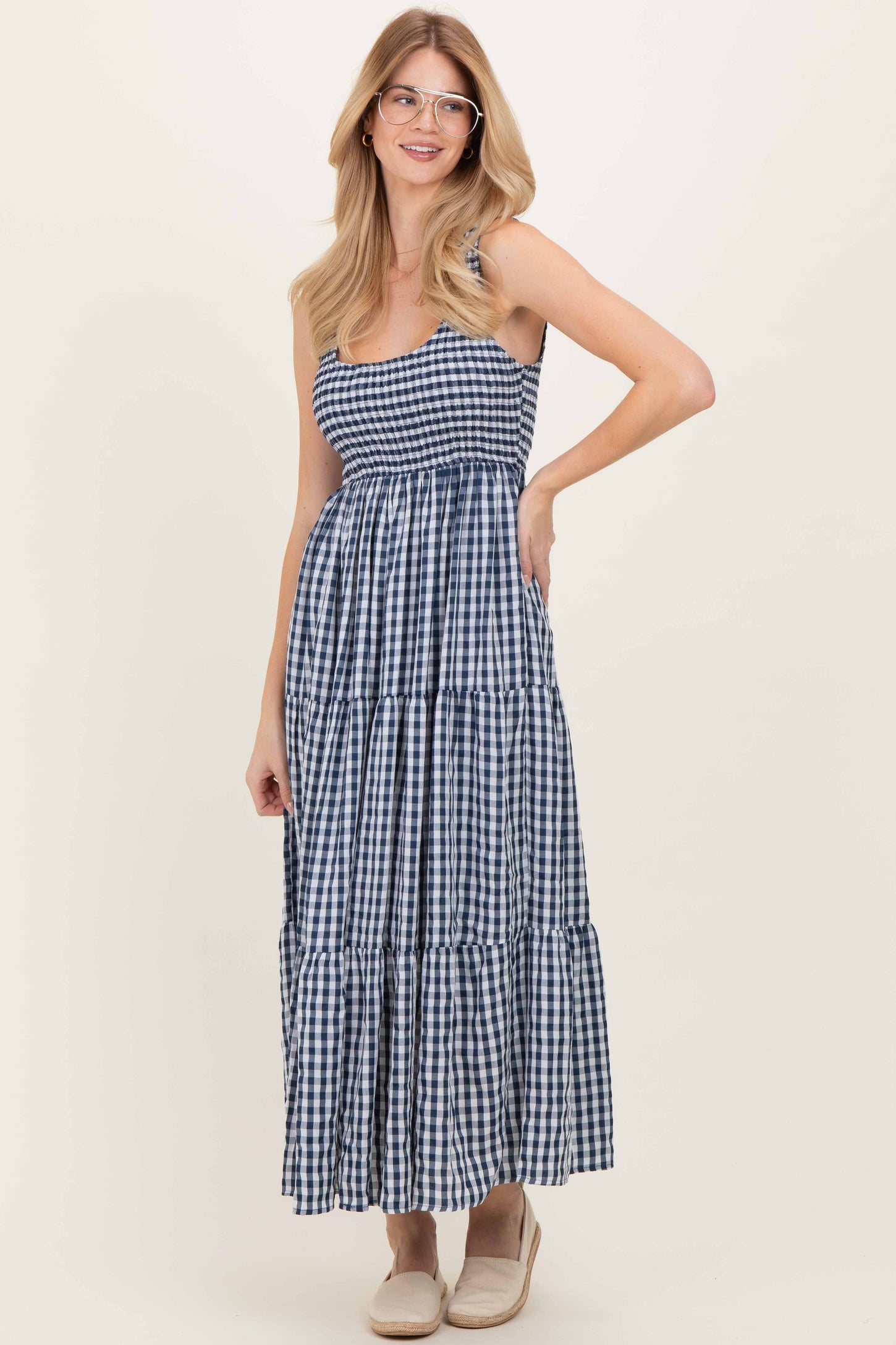 woman wearing a navy and white gingham maxidress with a smocked bodice and tiered skirt