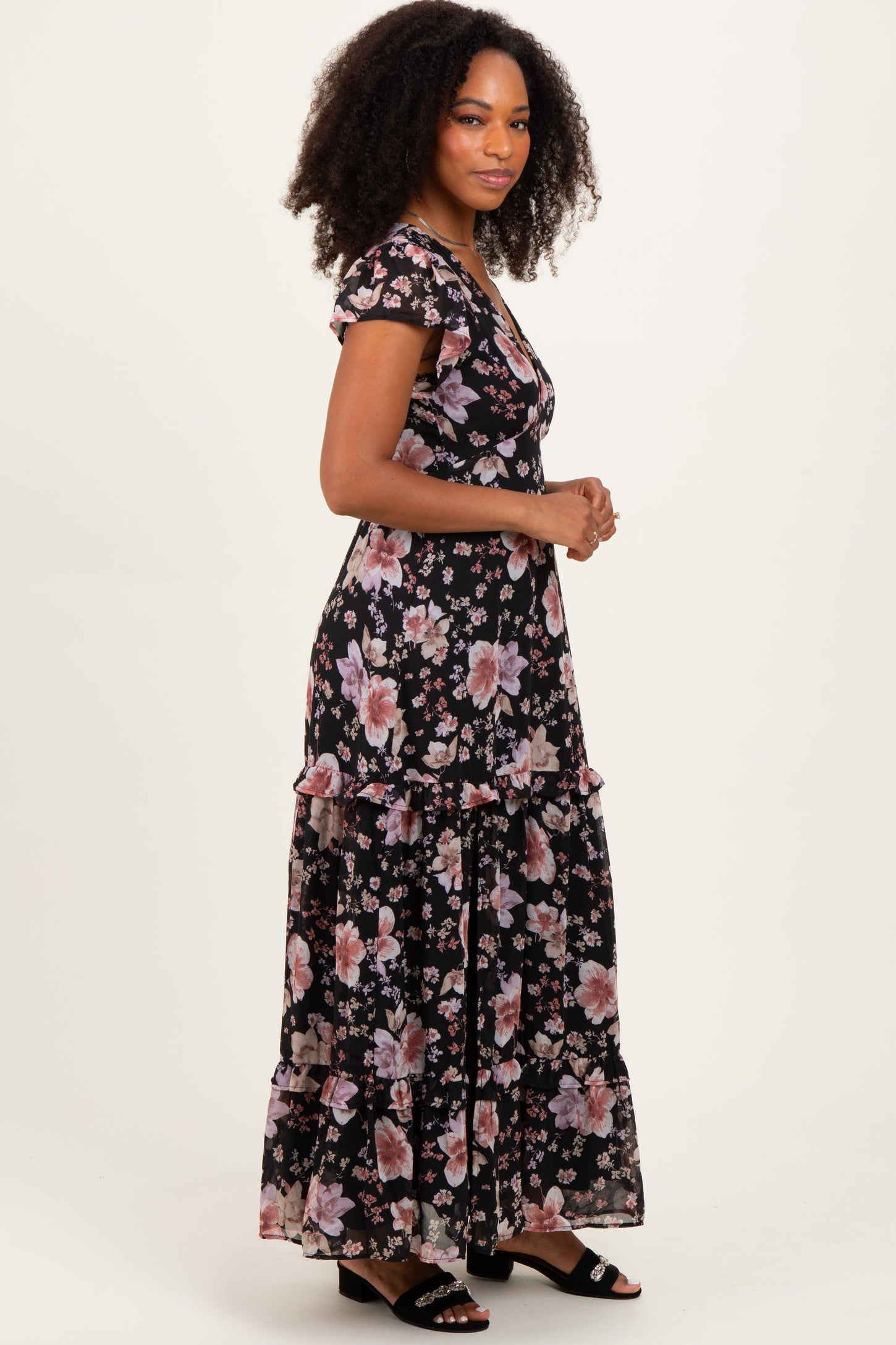 woman wearing a black floral maxi dress with short sleeves and ruffle details