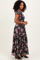 woman wearing a black floral maxi dress with short sleeves and ruffle details