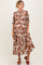 woman wearing a brown and white floral maxi maternity dress with short sleeves and a button-up front, showcasing her baby bump