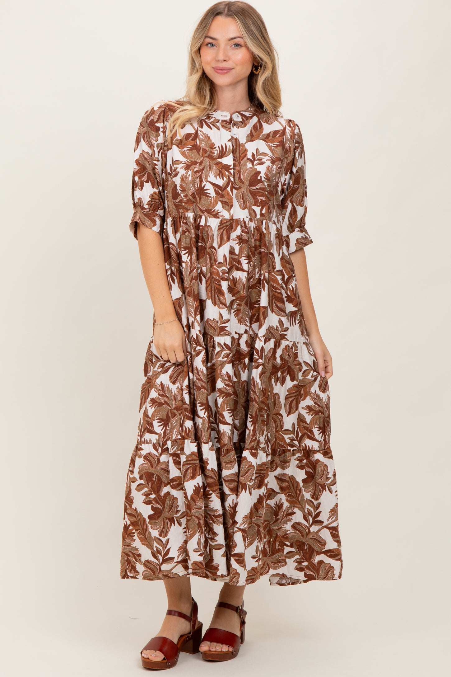 woman wearing a brown and white floral maxi dress with short sleeves and pockets