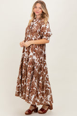 woman wearing a brown and white floral maxi dress with a tiered skirt and short sleeves