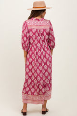 woman wearing a pink floral print maternity maxi dress with a flowy silhouette and puff sleeves