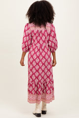 woman wearing a pink floral long sleeve maxi dress with a smocked back and tiered hem