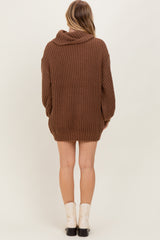 woman wearing a brown oversized ribbed sweater dress with a hood and long sleeves, shown from the back