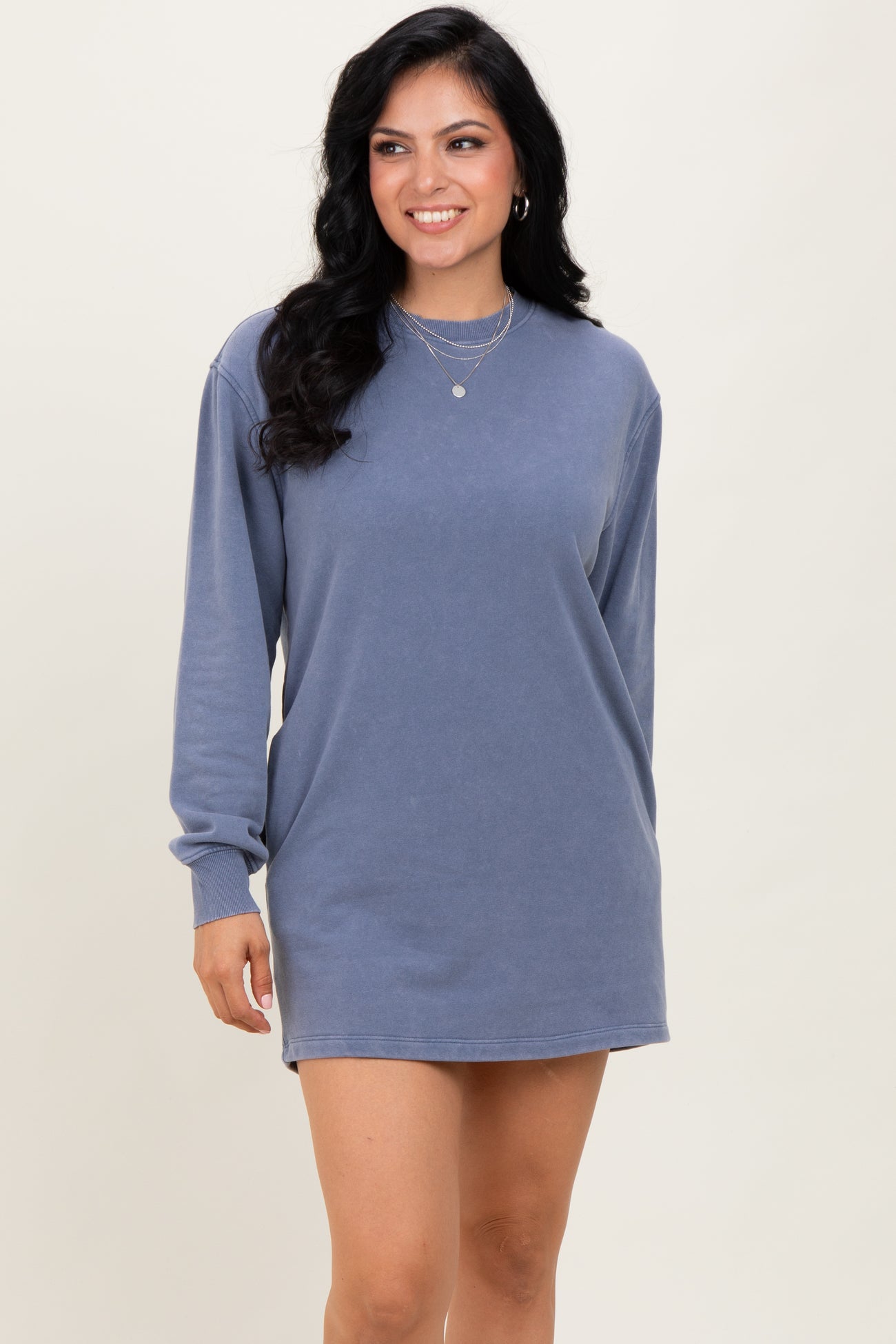 woman wearing a blue long sleeve oversized sweatshirt dress with a relaxed fit and round neckline