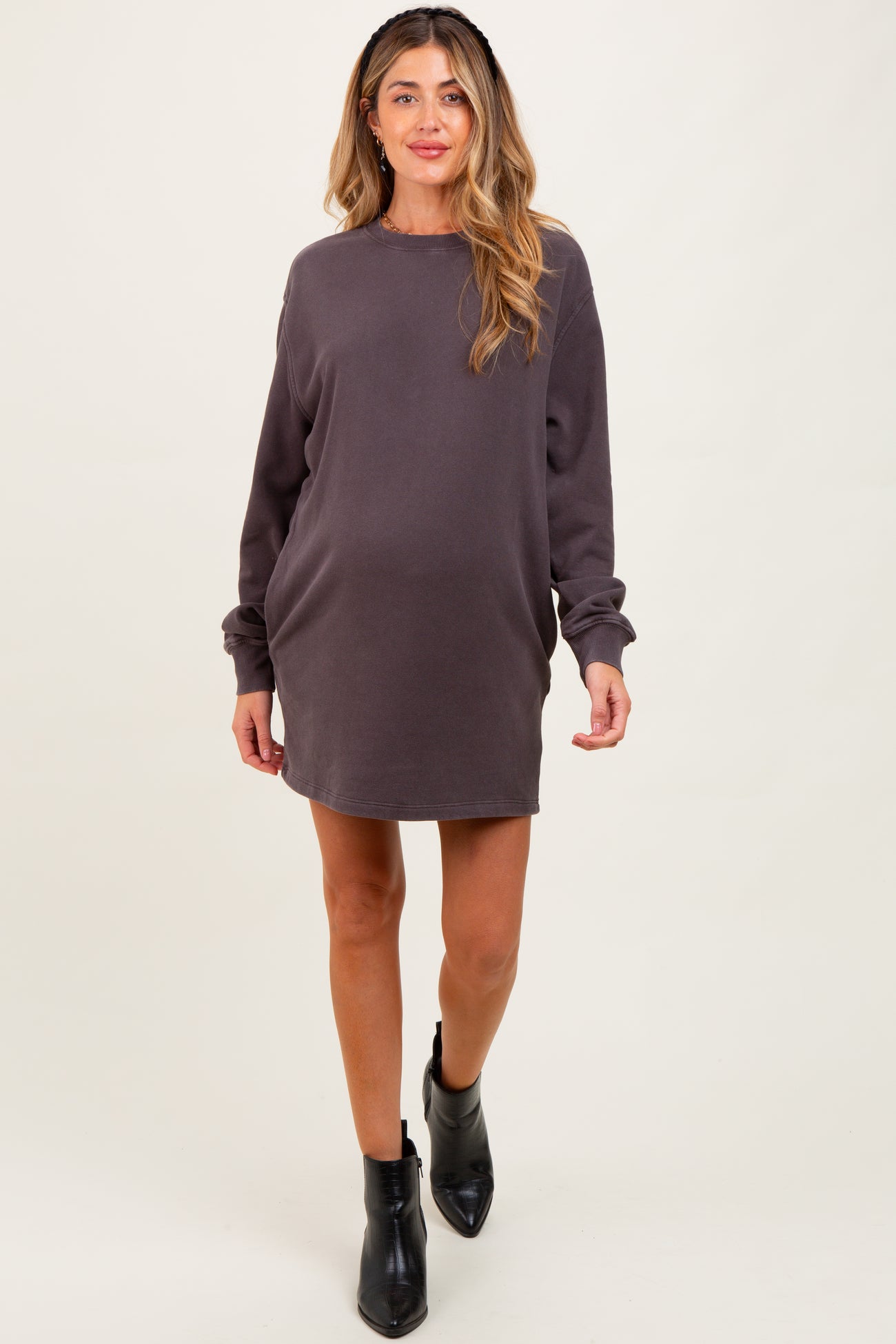 woman wearing a dark gray maternity sweatshirt dress with long sleeves and a relaxed fit, showing her baby bump