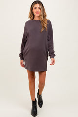 woman wearing a dark gray maternity sweatshirt dress with long sleeves and a relaxed fit, showing her baby bump