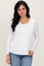 woman wearing a white long sleeve top with a round neckline and paired with blue jeans