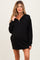 woman wearing a black maternity pullover dress with a half-zip collar and long sleeves, showcasing a baby bump