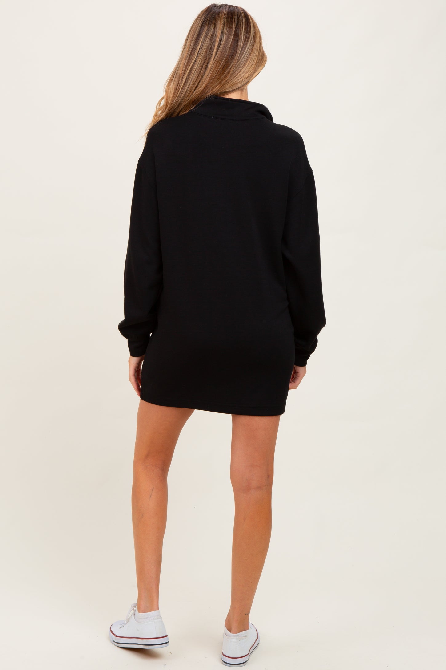 woman wearing a black maternity sweatshirt dress, shown from the back with long sleeves and a relaxed fit