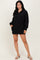 woman wearing a black long sleeve pullover dress with a quarter zip and side pockets