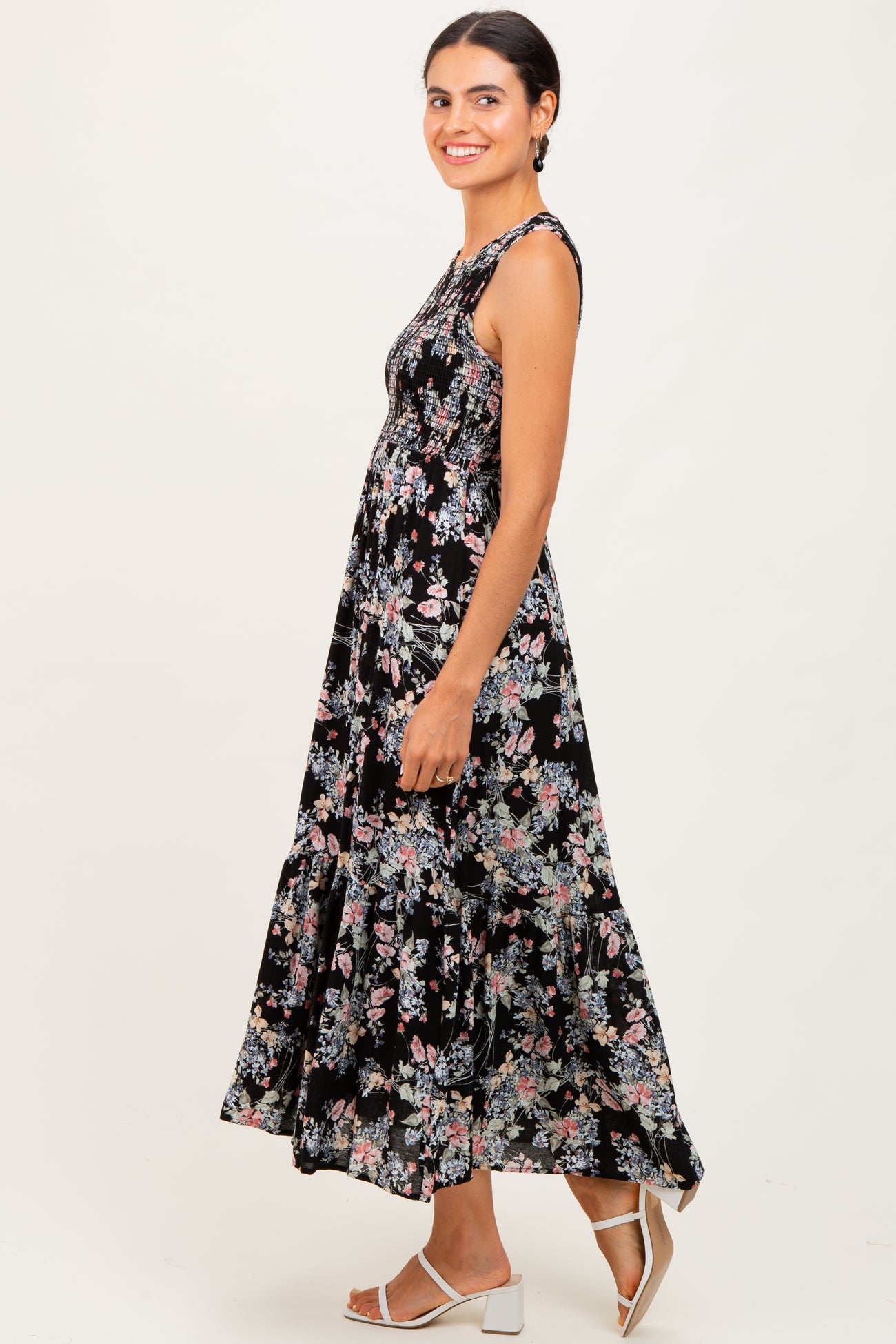 woman wearing a black floral maxi dress with tiered ruffles and a fitted bodice