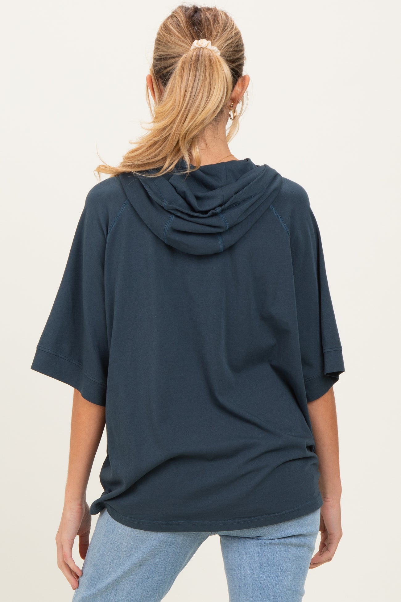 woman wearing a navy blue oversized hoodie with a hood, shown from the back, maternity wear