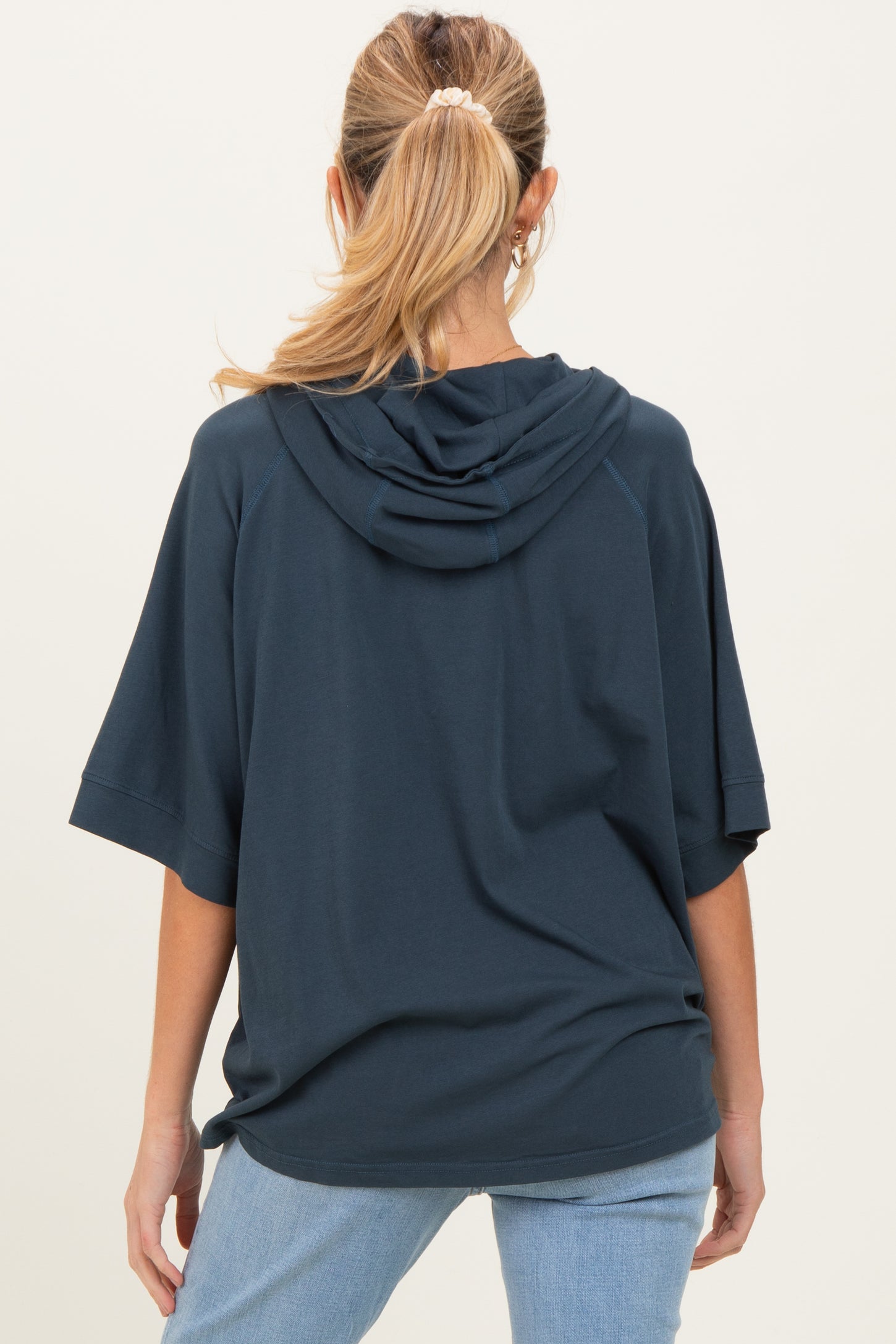 woman wearing a navy blue oversized hoodie with a hood, shown from the back, maternity wear