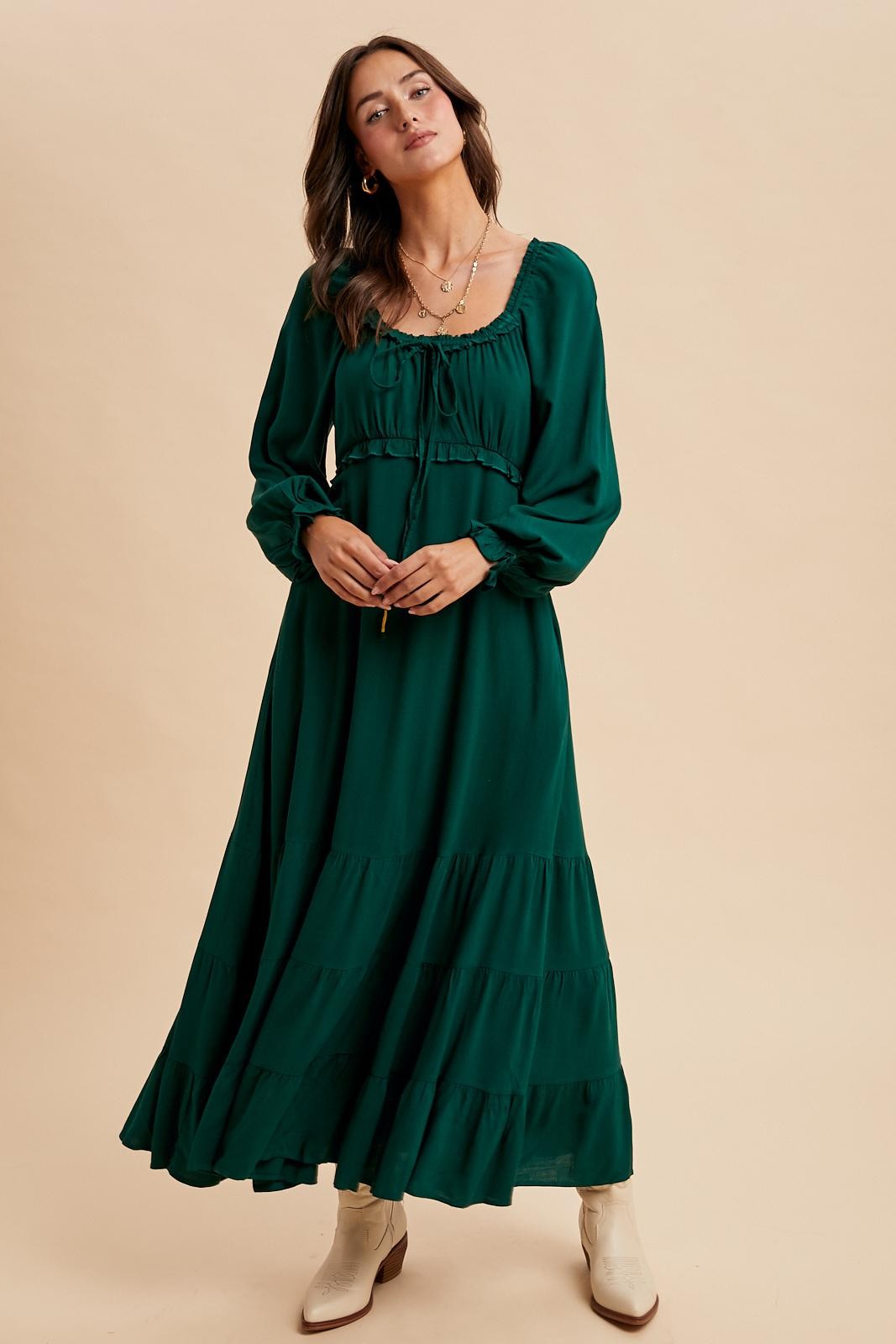 woman wearing a long green tiered maxi dress with puff sleeves and a square neckline