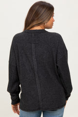 woman wearing a dark gray maternity sweater with a back seam detail