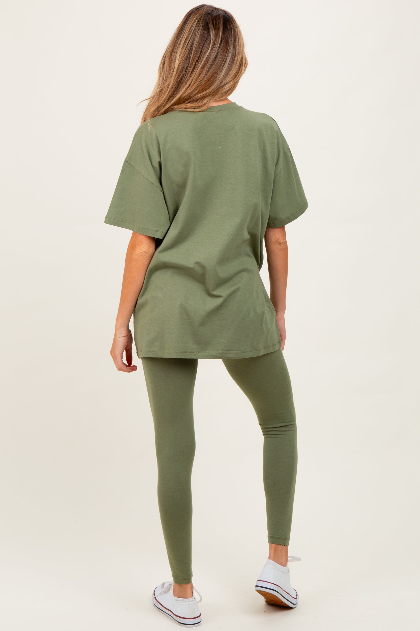 woman wearing an olive green oversized t-shirt and matching leggings, showcasing comfortable maternity wear