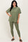 woman wearing an olive green oversized t-shirt and matching leggings, standing with one hand on her hip