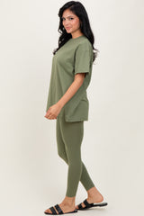woman wearing an olive green oversized t-shirt and matching fitted leggings with open-toe sandals
