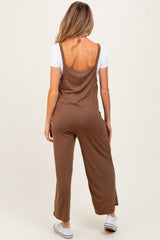 woman wearing a brown maternity jumpsuit with a fitted bodice and wide leg, showing bare back and casual style