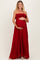 woman wearing a red off-the-shoulder maternity gown and holding her baby bump