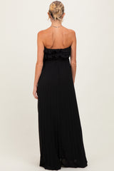 woman wearing a black strapless maternity maxi dress with ruffle detailing and pleated fabric
