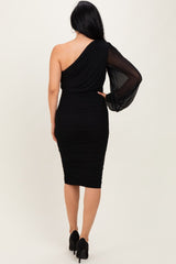 woman wearing a black one-shoulder ruched dress with a sheer long sleeve and fitted silhouette