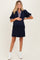 woman wearing a navy blue maternity dress with plaid accent sleeves and holding her baby bump