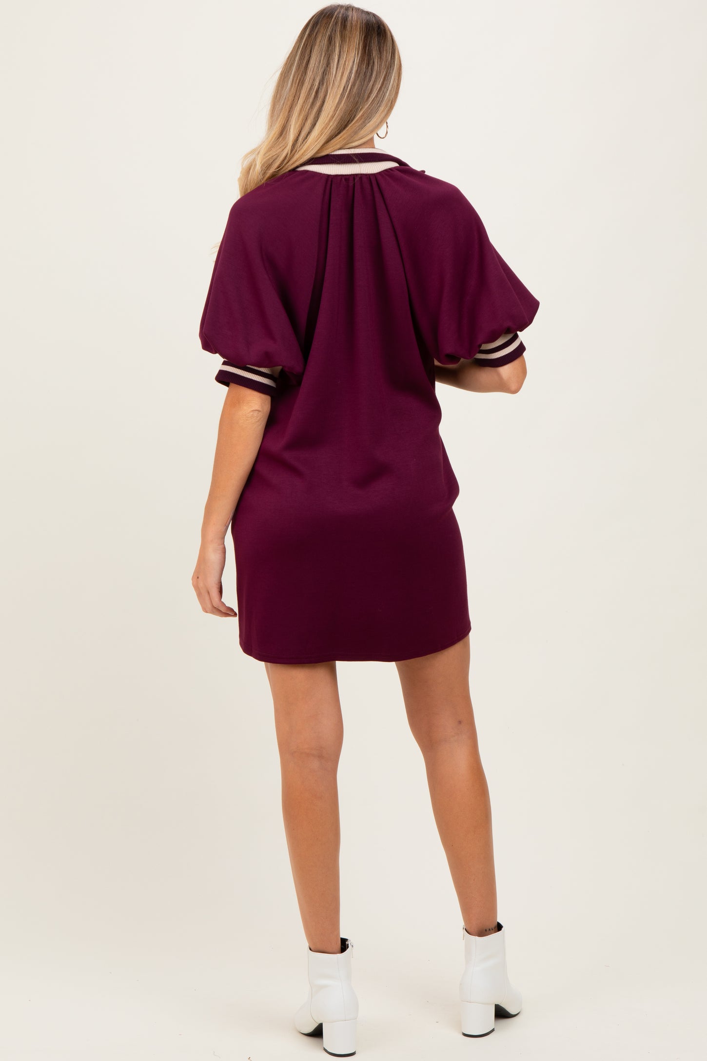 woman wearing a burgundy maternity dress with short puff sleeves and a sporty style, showing her back
