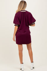 woman wearing a burgundy maternity dress with short puff sleeves and a sporty style, showing her back