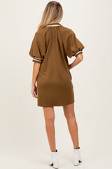 woman wearing a brown maternity dress with short puff sleeves and striped collar, showing a baby bump from the back