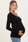 woman wearing a black ribbed long sleeve maternity top and holding her baby bump