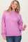 woman wearing a light purple oversized hooded sweatshirt with drawstrings and ribbed hem, paired with blue jeans