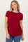 woman wearing a red short sleeve top paired with blue jeans